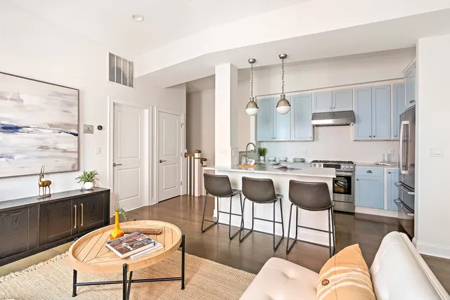a living room with stainless steel appliances kitchen island granite countertop furniture and a large window