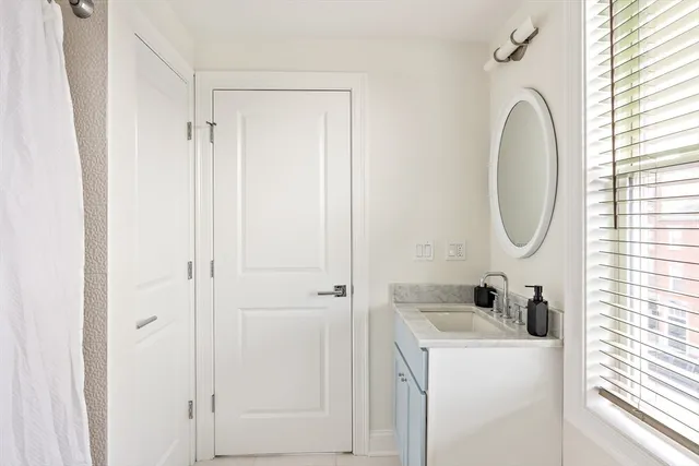 a bathroom with a granite countertop sink and a mirror