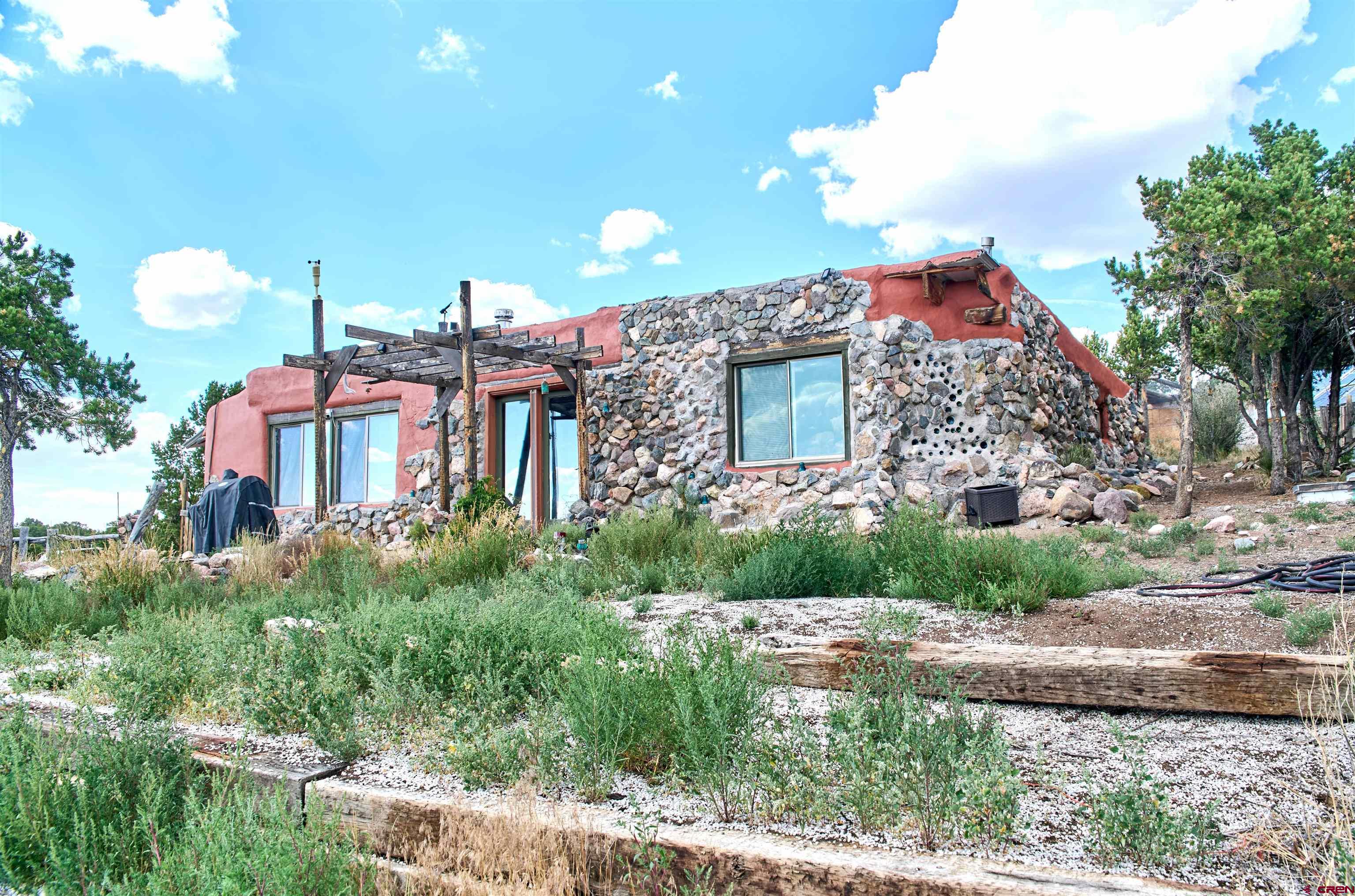 1380 Dunn Road Fort Garland, CO 81133 - Photo 2 of 45 a view of a house with a yard and potted plants