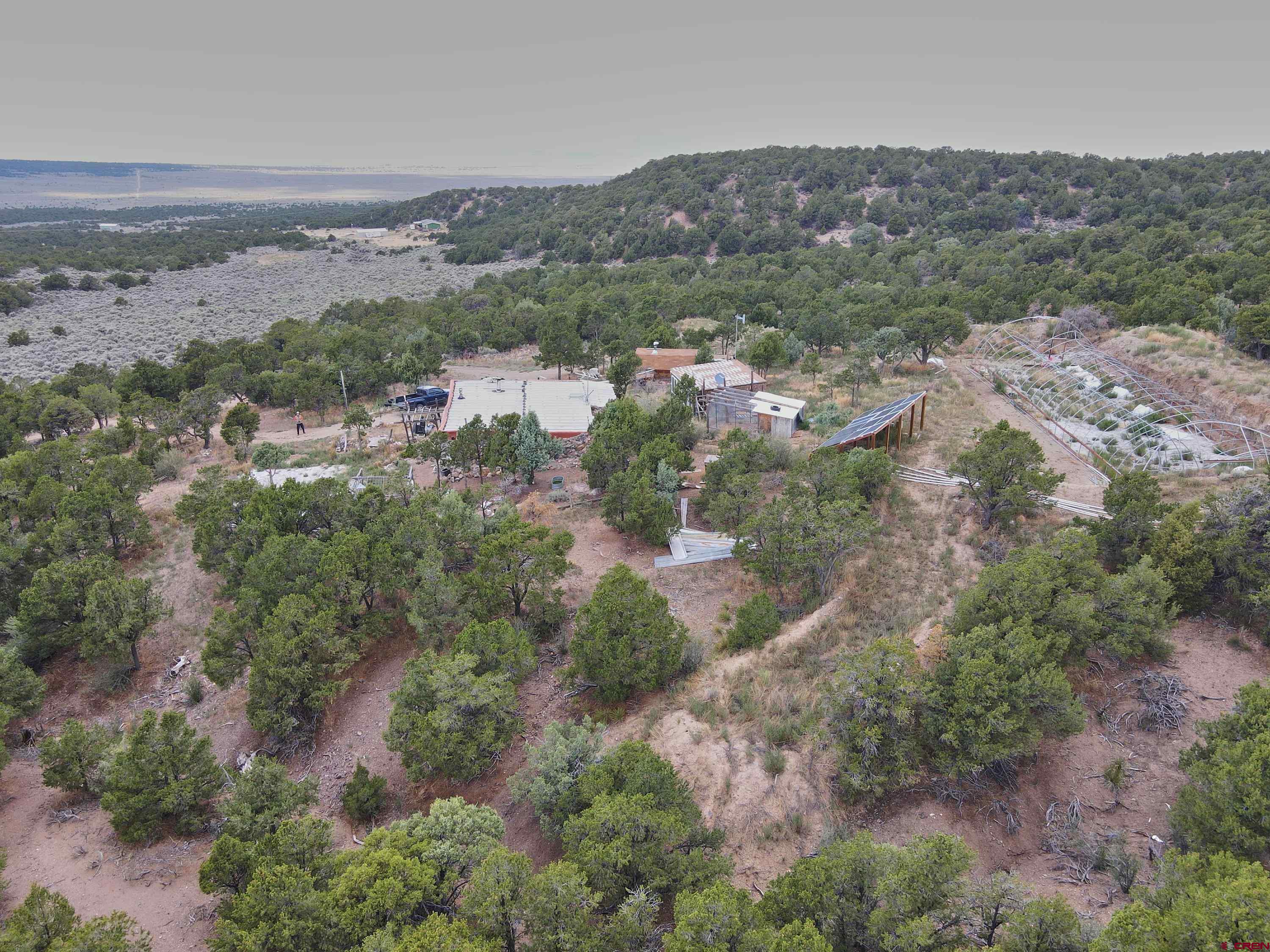 1380 Dunn Road Fort Garland, CO 81133 - Photo 34 of 45 an aerial view of green landscape with trees houses and mountain view