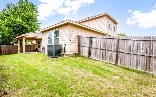 a view of a backyard with wooden fence