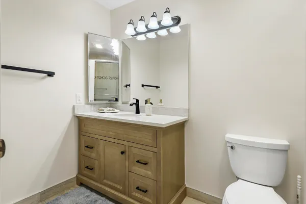 a bathroom with a toilet sink and mirror