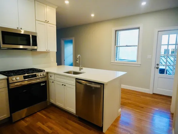 a kitchen with stainless steel appliances granite countertop a sink stove and microwave