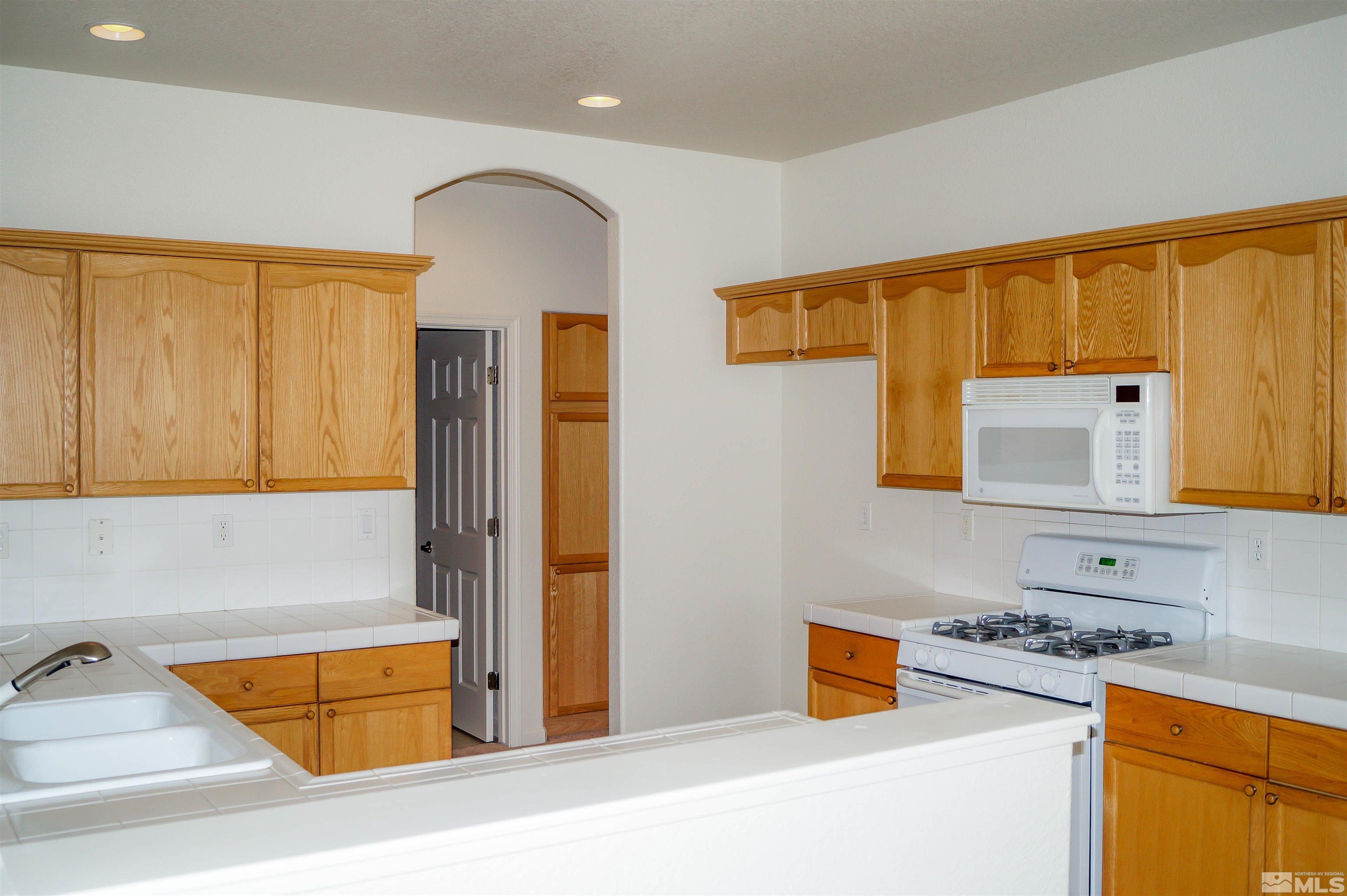 1747 Canyon Shadow Circle Reno, NV 89521 - Photo 4 of 14 a kitchen with stainless steel appliances granite countertop a sink and a stove next to a window