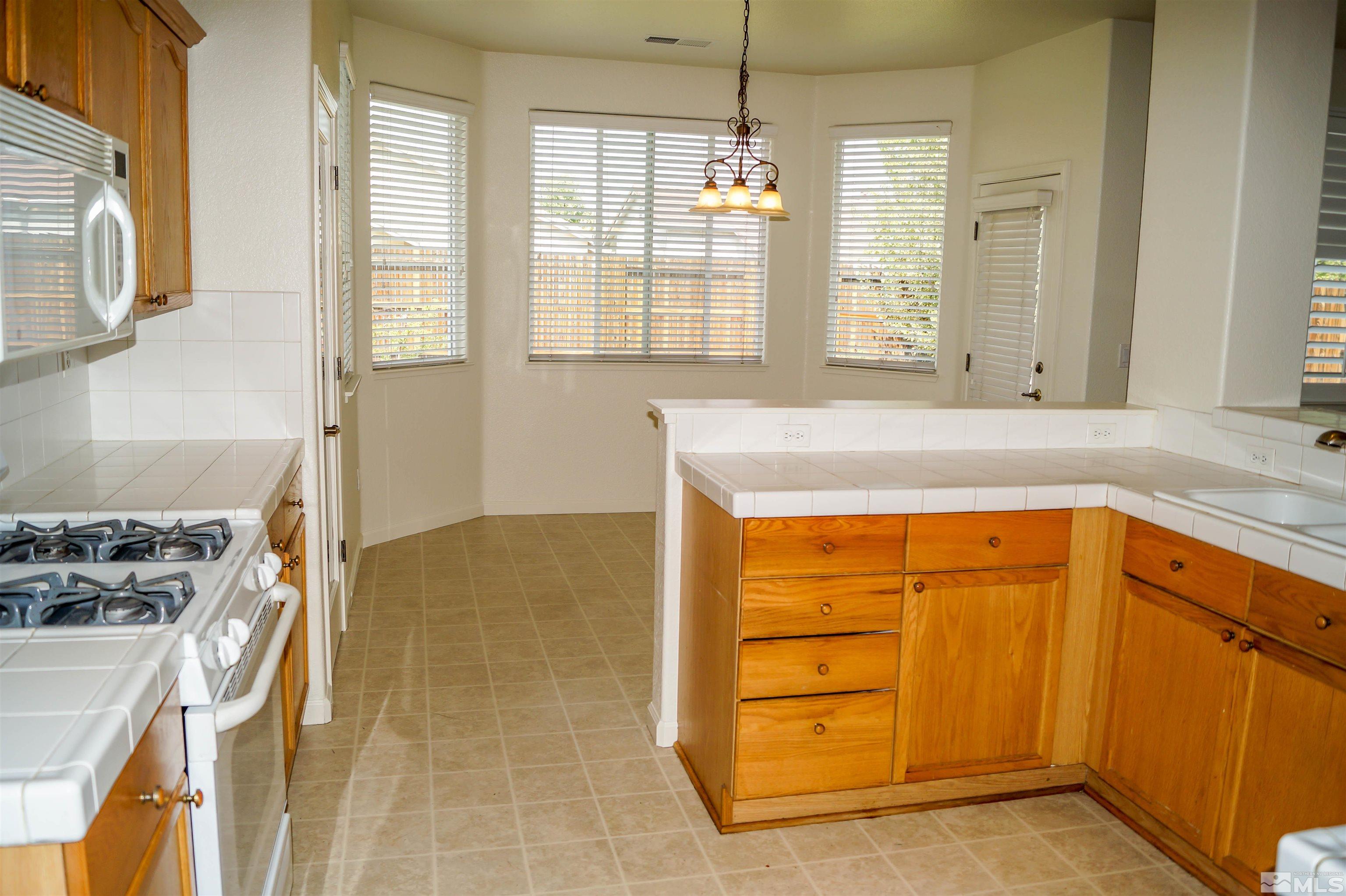 1747 Canyon Shadow Circle Reno, NV 89521 - Photo 6 of 14 a kitchen with a stove a sink and a refrigerator