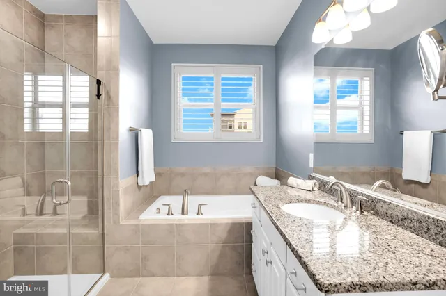 a bathroom with a granite countertop tub sink and mirror