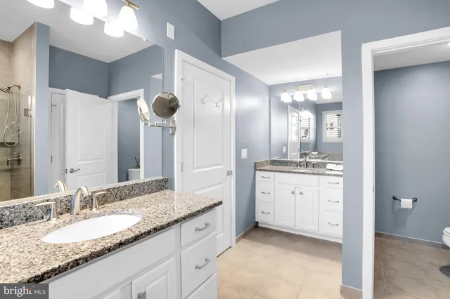 a bathroom with a granite countertop sink mirror and double