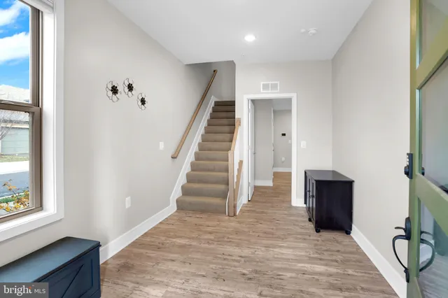 a view of a hallway with wooden floor and staircase