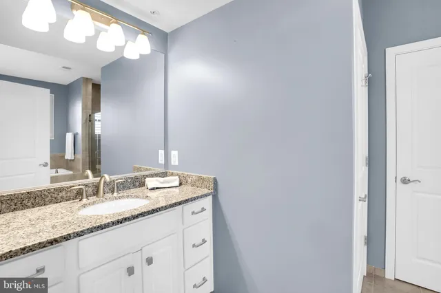 a bathroom with a granite countertop sink and a mirror