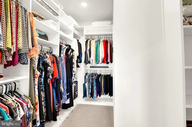 a view of walk in closet with clothes