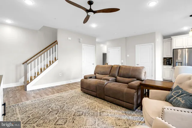 a living room with furniture and a ceiling fan