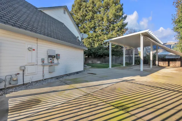 a view of a house with a yard and a large tree
