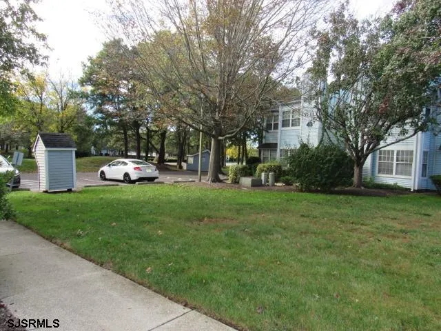a front view of a house with a garden and trees
