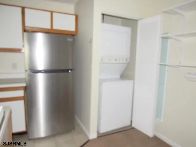 a view of kitchen with refrigerator and wooden floor