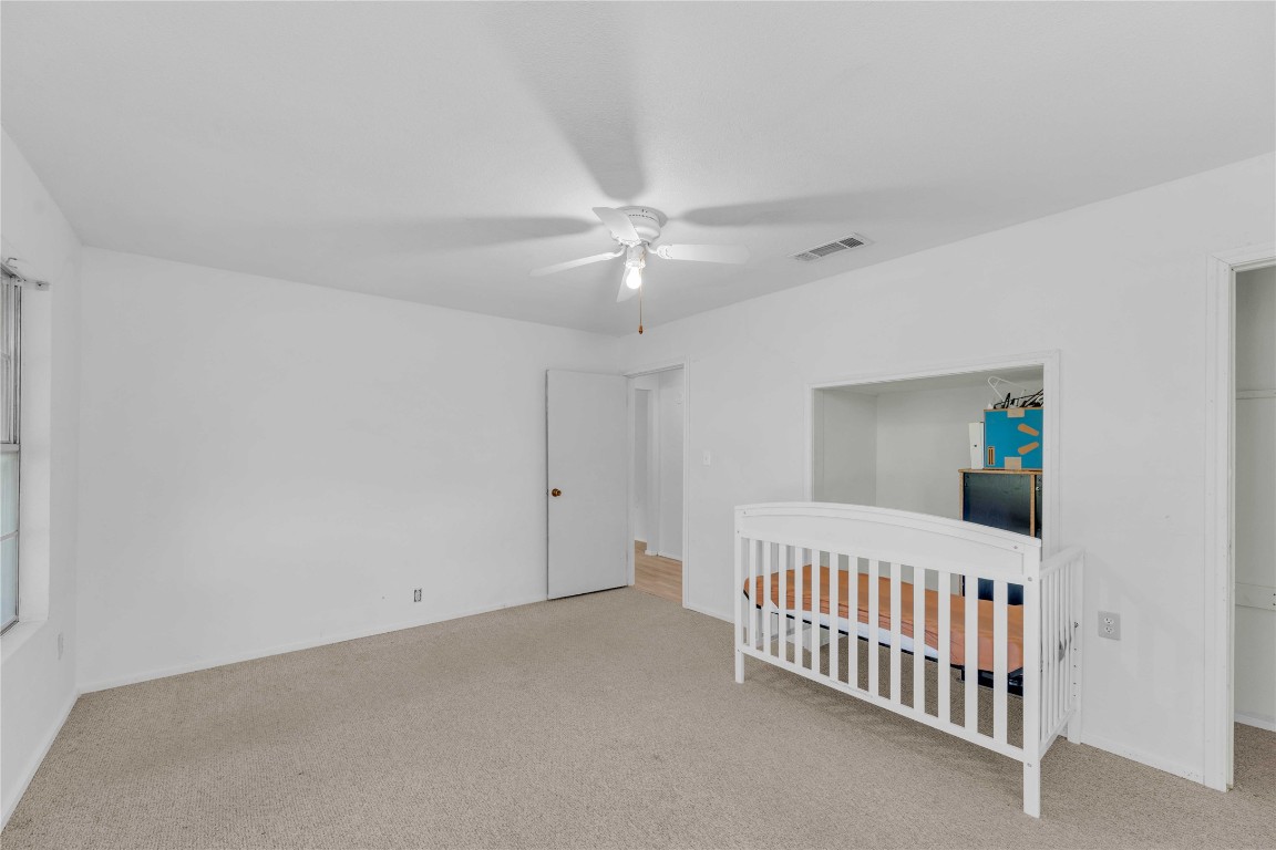 20235 Engelmann Lane Manor, TX 78653 - Photo 15 of 34 a bedroom with windows and a chandelier fan