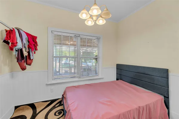 a bedroom with a bed and a chandelier