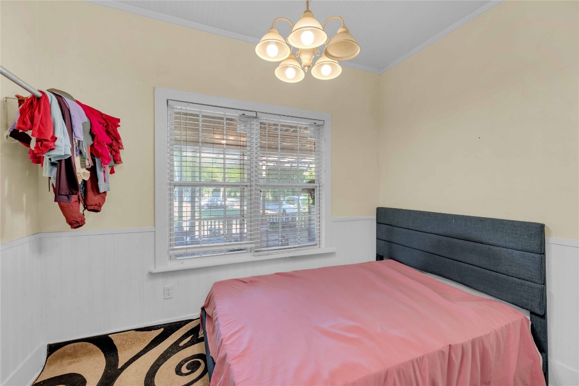 20235 Engelmann Lane Manor, TX 78653 - Photo 28 of 34 a bedroom with a bed and a chandelier