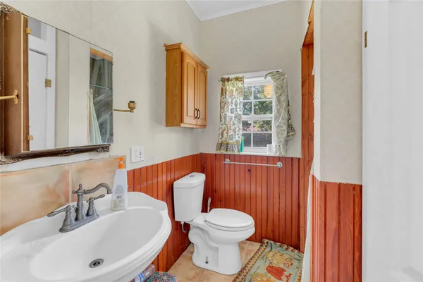 a bathroom with a sink a toilet and a mirror