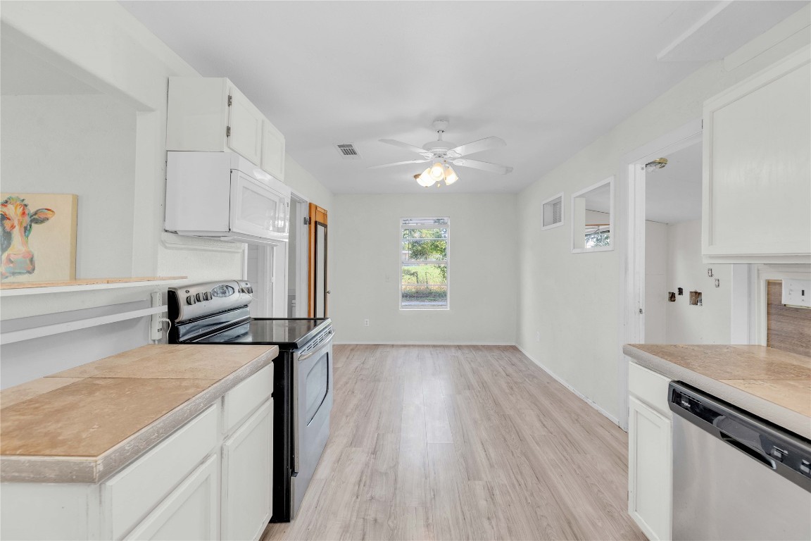 20235 Engelmann Lane Manor, TX 78653 - Photo 8 of 34 a kitchen with a stove a sink and a refrigerator