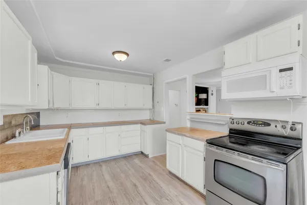 a kitchen with a sink stove and cabinets