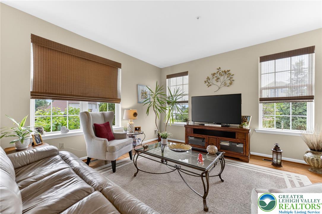 5440 Spring Ridge Drive West Macungie, PA 18062 - Photo 13 of 40 Sun-filled living space featuring hardwood floors and elegant window treatments.