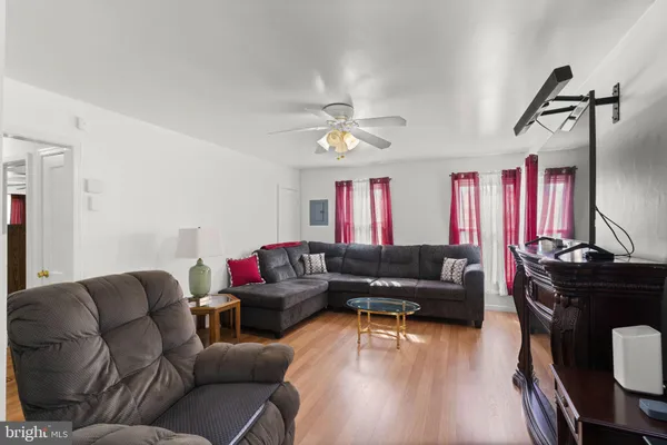 a living room with furniture ceiling fan and a wooden floor