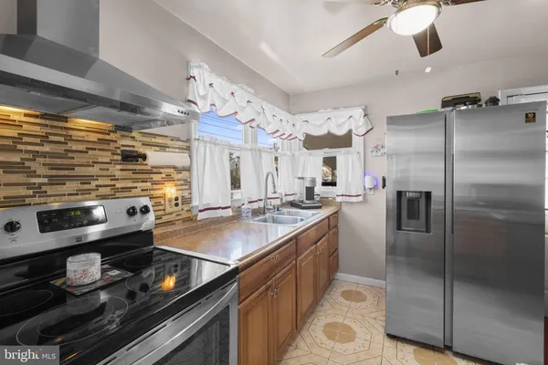 a kitchen with stainless steel appliances granite countertop a sink and a refrigerator