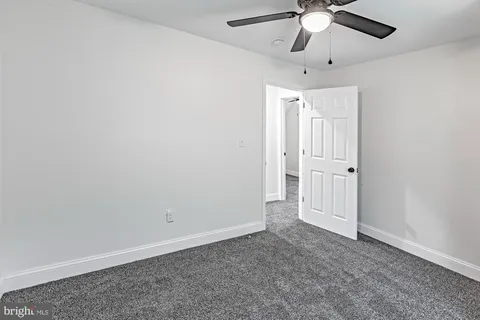 an empty room with chandelier fan