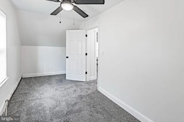 an empty room with chandelier fan