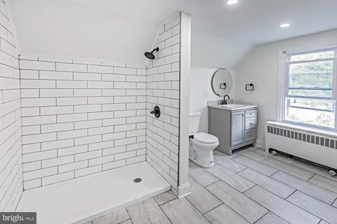 a bathroom with a bathtub shower sink mirror and toilet