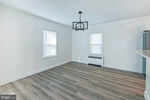 a view of empty room with wooden floor and window