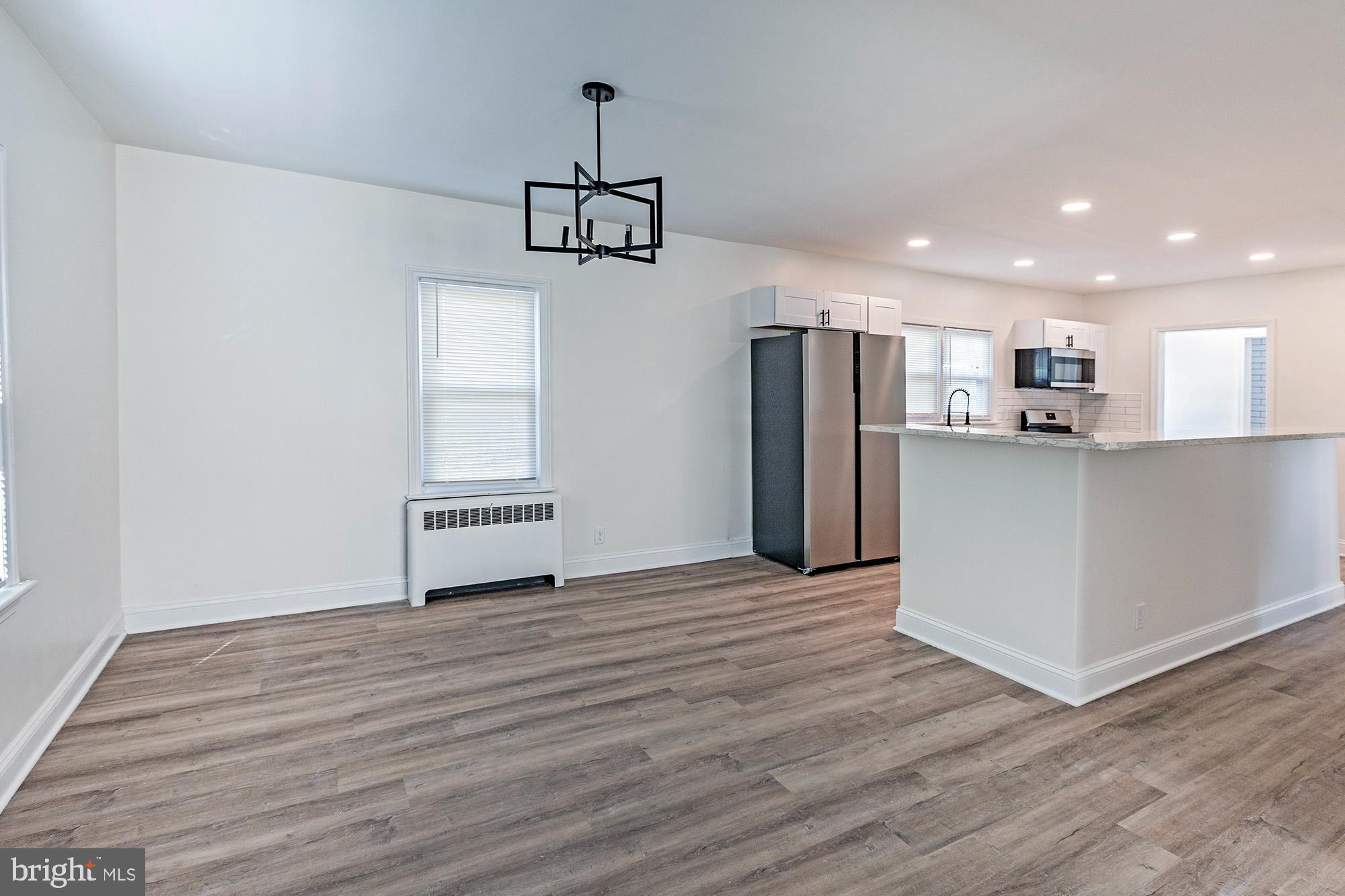111 Grove Street Penns Grove, NJ 08069 - Photo 7 of 27 a view of a kitchen with a refrigerator wooden floor and a ceiling fan