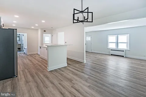 a kitchen with stainless steel appliances granite countertop a refrigerator a stove and a wooden floors