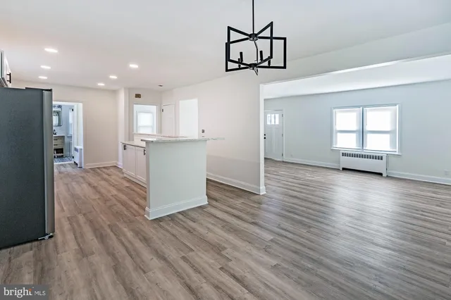 a kitchen with stainless steel appliances granite countertop a refrigerator a stove and a wooden floors