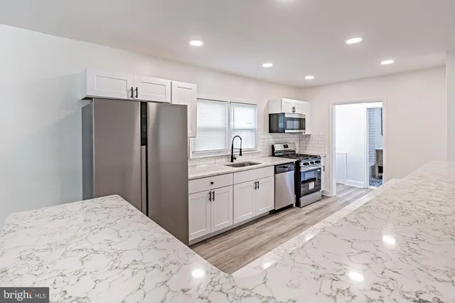 a kitchen with granite countertop a refrigerator and a sink