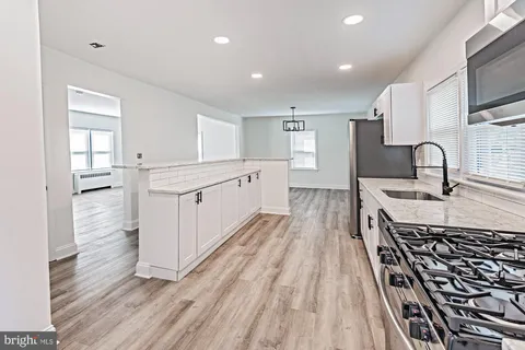a large kitchen with kitchen island a sink stainless steel appliances and cabinets