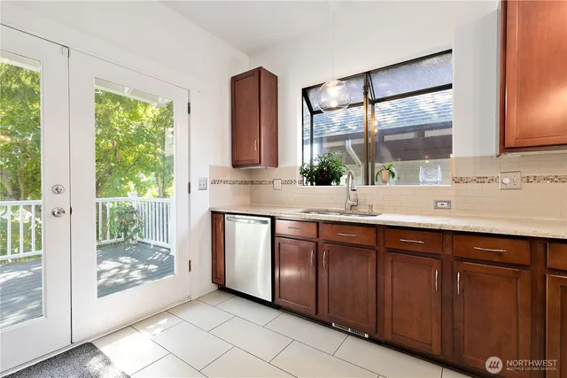 a kitchen with stainless steel appliances a sink window and cabinets