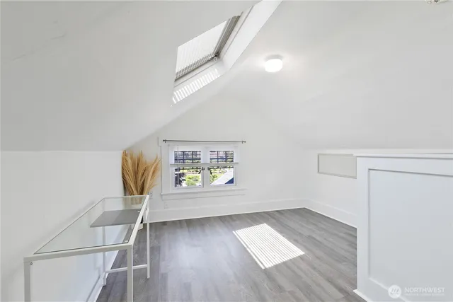 a view of hallway with window and wooden floor