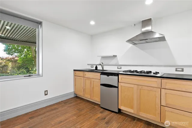 a kitchen with granite countertop white cabinets and a wooden floor