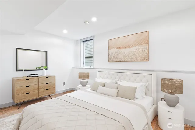 a bedroom with a bed and a flat tv screen on dresser