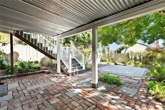 a view of a patio with table and chairs and wooden fence