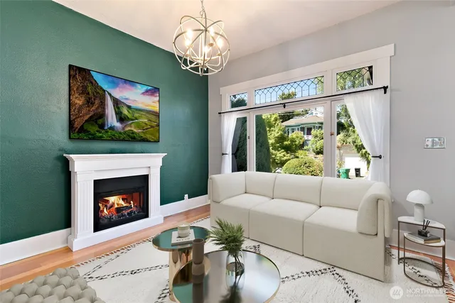 a living room with furniture a chandelier and a fireplace