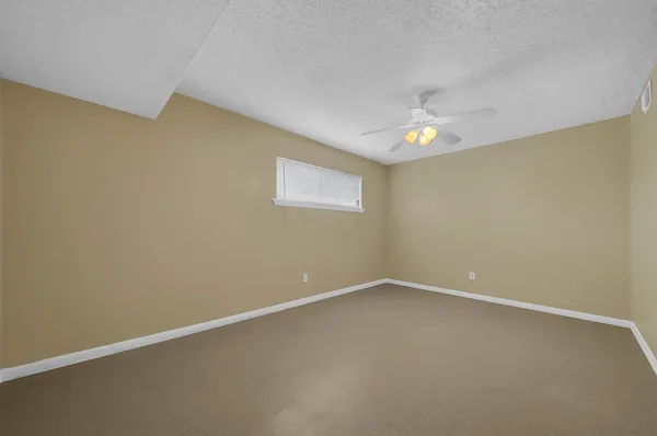 an empty room with a ceiling fan and a window