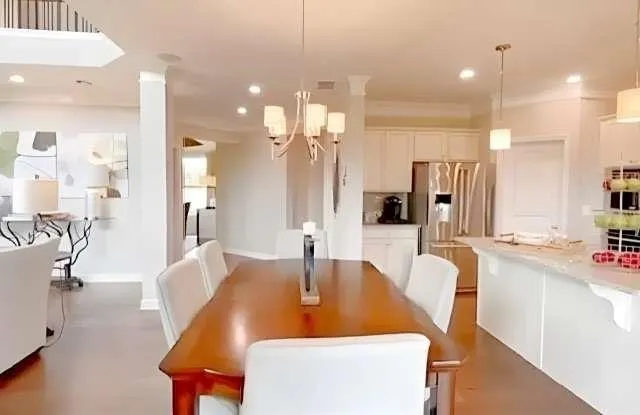 a large kitchen with a table chairs refrigerator and a sink