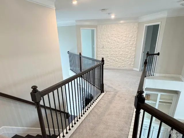 a view of a hallway with wooden floor and stairs