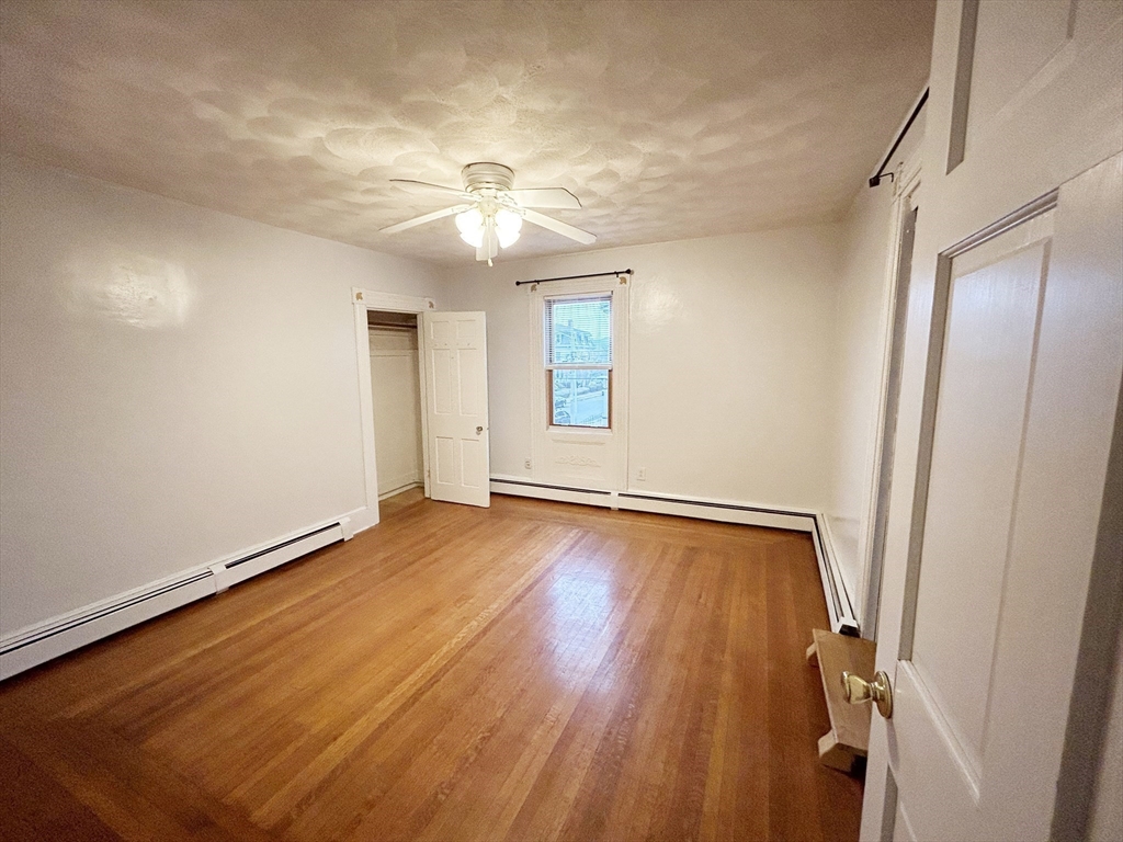 25 Baltimore Street, Unit 2/3 Lynn, MA 01902 - Photo 13 of 36 wooden floor in an empty room with a window