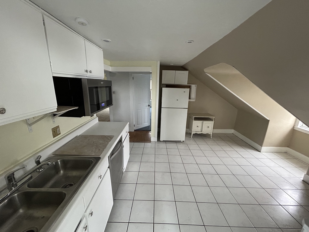 25 Baltimore Street, Unit 2/3 Lynn, MA 01902 - Photo 23 of 36 a kitchen with a sink appliances and cabinets