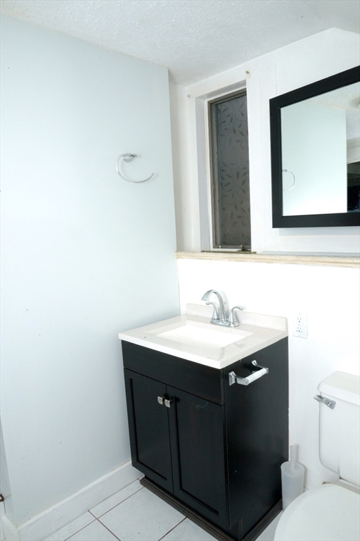 25 Baltimore Street, Unit 2/3 Lynn, MA 01902 - Photo 27 of 36 a bathroom with a toilet sink and mirror