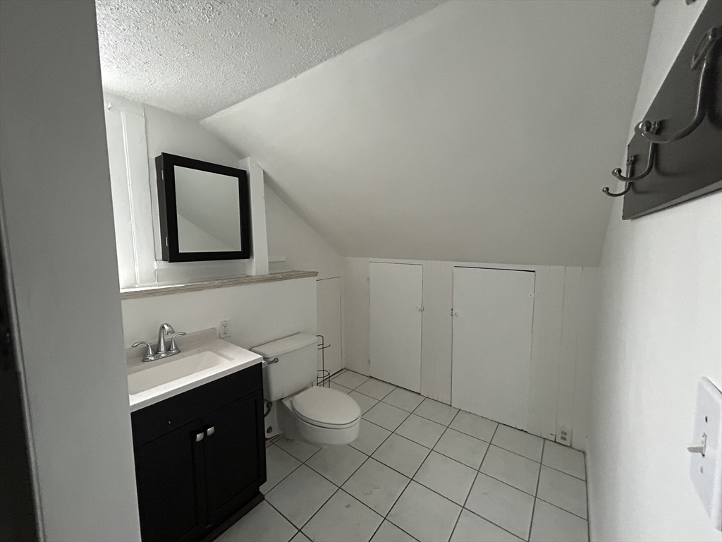 25 Baltimore Street, Unit 2/3 Lynn, MA 01902 - Photo 28 of 36 a bathroom with a sink and a mirror
