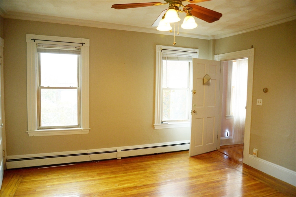 25 Baltimore Street, Unit 2/3 Lynn, MA 01902 - Photo 3 of 36 a view of an empty room with wooden floor and a window